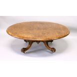 A VICTORIAN FIGURED WALNUT OVAL TILT TOP TABLE, on four carved, curving legs (reduced in height).