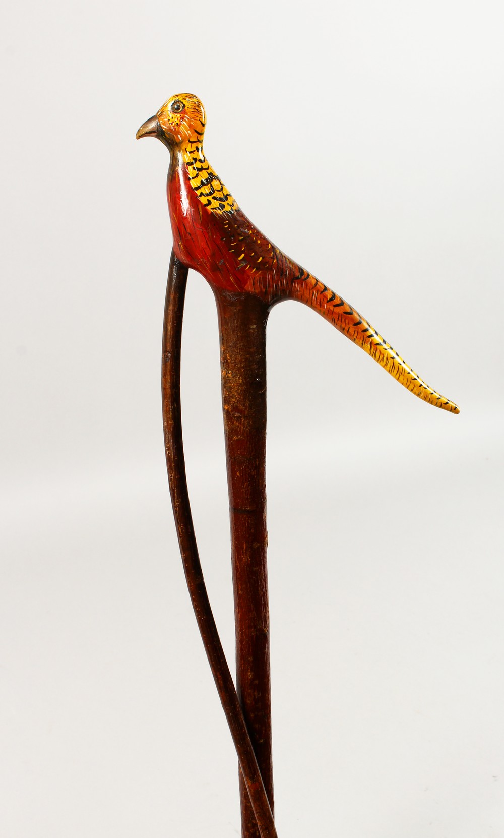 AN ENTWINED WALKING STICK, the handle carved as a pheasant. 55ins long.