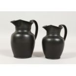 TWO PLAIN WEDGWOOD BLACK BASALT MILK JUGS. (2) Impressed WEDGWOOD. 5ins and 4.5ins high.