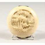 A 1920'S CONTINENTAL CARVED IVORY COMPACT, carved with palm trees, mirror inside. 2.5ins diameter.
