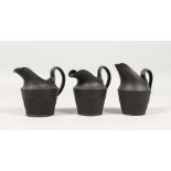 THREE SMALL WEDGWOOD-STYLE BLACK BASALT CREAM JUGS. 3.5ins high. (Unmarked) (3)