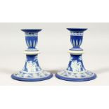 A PAIR OF WEDGWOOD BLUE AND WHITE JASPER WARE CIRCULAR CANDLESTICKS. Impressed WEDGWOOD. 4.5ins