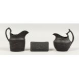 A SMALL WEDGWOOD BLACK BASALT TRINKET BOX, 3.5ins long, and two milk jugs (3).