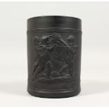 A WEDGWOOD BLACK BASALT MUG, with cupids carrying a boars head with laurel leaf handle Impressed