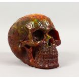 AN AMBER STYLE MODEL OF A HUMAN SKULL. 6ins wide.