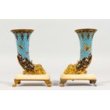 A GOOD PAIR OF 19TH CENTURY GILT METAL AND CLOISONNE CORNUCOPIA VASES, with rams masks, on onyx
