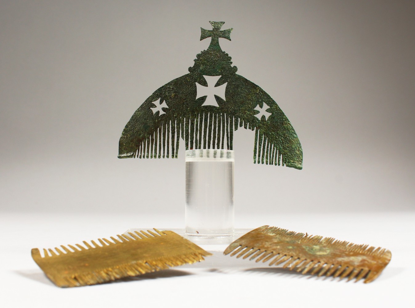 THREE BYZANTINE COMBS, one with a stand. 2.5ins and 3.75ins wide.