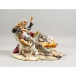 A CAPODIMONTE GROUP, a man on a chaise longue, a dog by his side. 9.5ins wide.