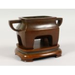 A CHINESE RECTANGULAR TWIN-HANDLED BRONZE CENSER ON STAND. 6ins wide.