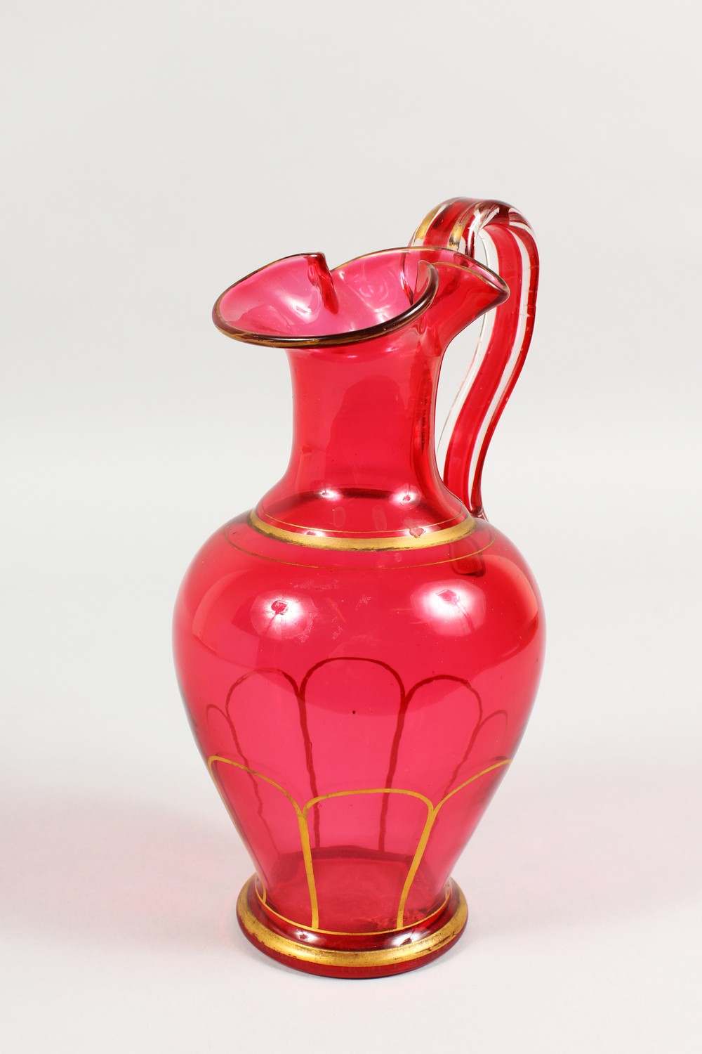 A VICTORIAN RUBY GLASS JUG. 9.5ins high.