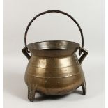 A 17TH/18TH CENTURY CAST METAL CAULDRON, on three feet with wrought iron handle. 9.5ins high.