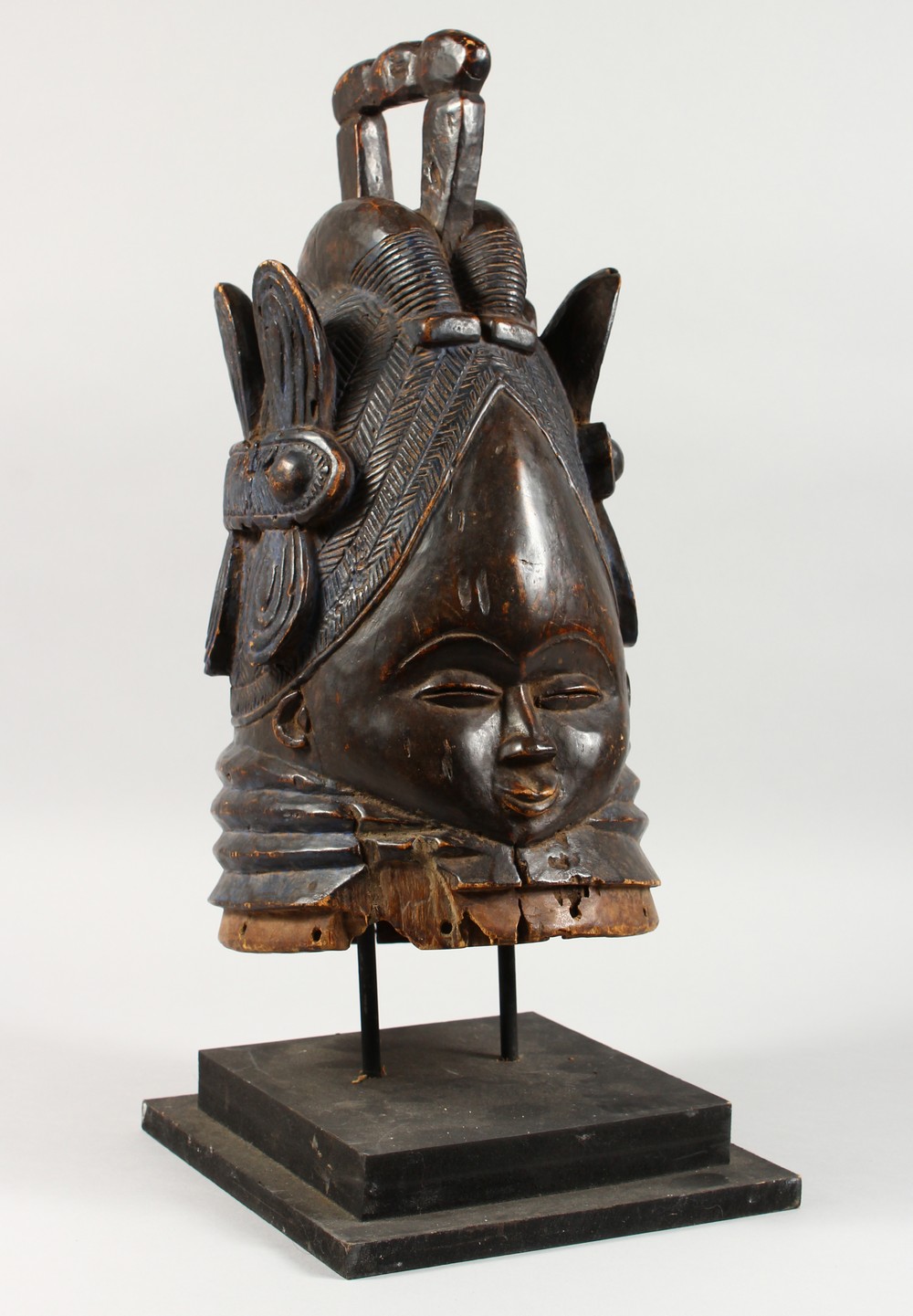 A GOOD CARVED WOOD TRIBAL HELMET MASK, on later stand. Mask: 18ins high.