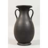 A PLAIN WEDGWOOD BLACK BASALT GRECIAN TYPE TWO-HANDLED VASE. Impressed WEDGWOOD. 9ins high.