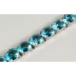 A SILVER BRACELET WITH NINETEEN OVAL CUT TOPAZ STONES.