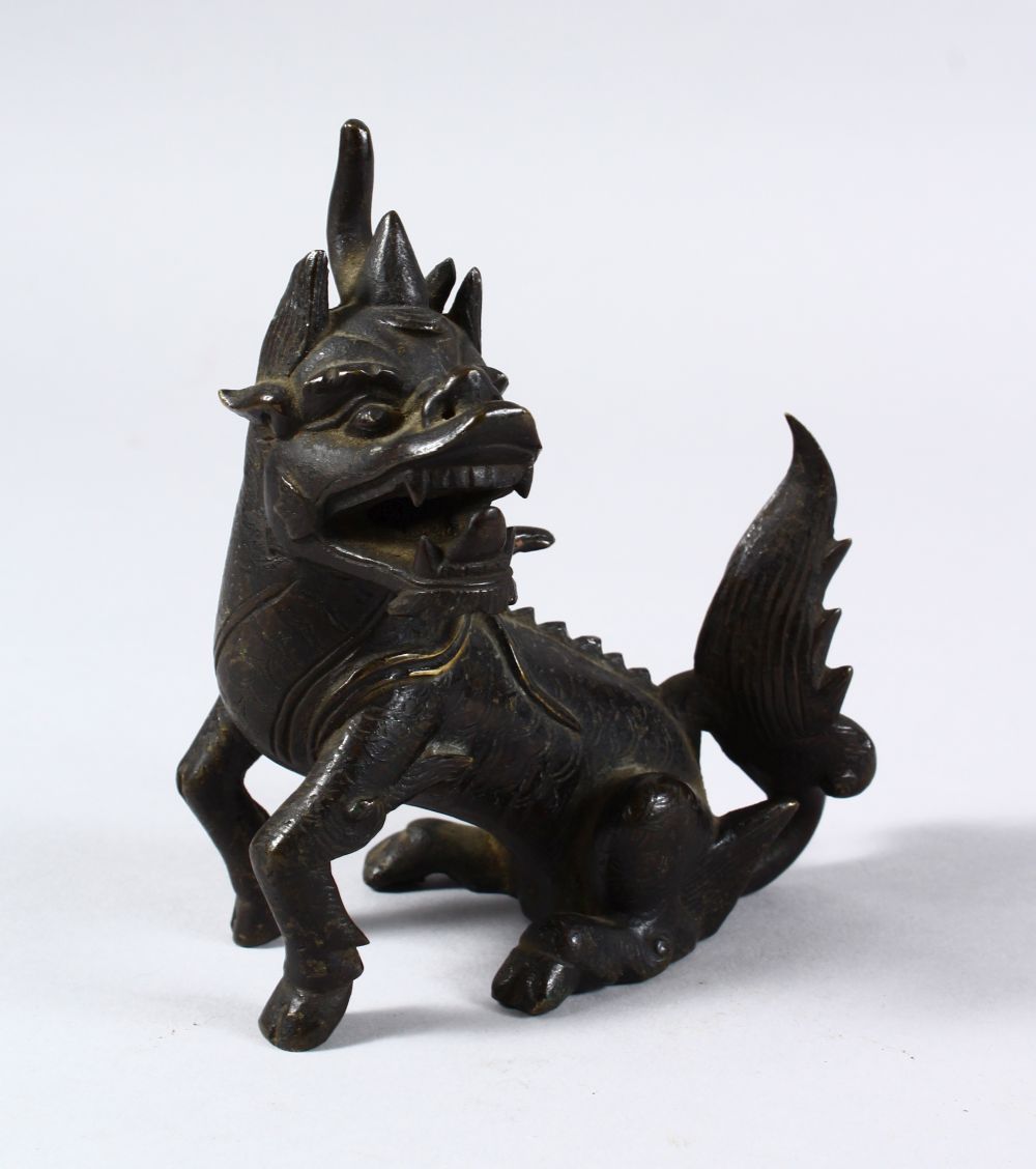 AN 18TH / 19TH CENTURY OR EARLIER CHINESE BRONZE FIGURE OF KYLIN, in a seated position with its