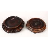 TWO 19TH CENTURY CHINESE CARVED HARDWOOD STANDS, housing vases 16.8cm & 16.3cm.(2)