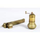 AN ISLAMIC BRASS PEN BOX AND GRINDER, decorated with calligraphy, grinder 11.5cm high , length of
