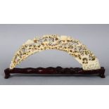 A 19TH CENTURY CARVED IVORY TUSK BRIDGE, carved with figures amongst native landscapes and