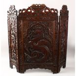 A GOOD 19TH CENTURY CHINESE CARVED HARDWOOD FOLDING FIRE SCREEN, the panels carved with scenes of