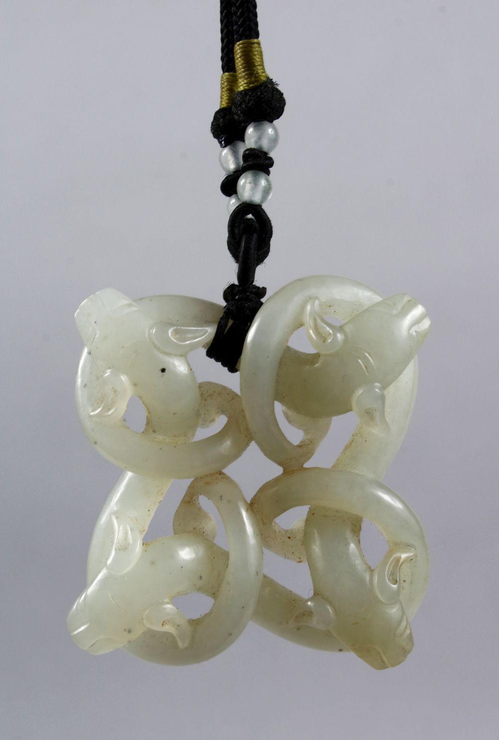 A GOOD 18TH / 19TH CENTURY CHINESE CARVED CELADON JADE PENDANT OF CHILONG, carved to depict four