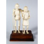 A GOOD 19TH CENTURY INIDIAN CARVED IVORY FIGURE OF AN ELDERLY COUPLE, on a mounted hardwood