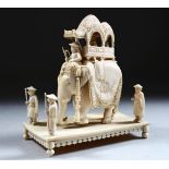 A 19TH CENTURY INDIAN CARVED IVORY FIGURE OF AN ELEPHANT AND ATTENDANTS, in a striding position with