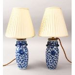 A PAIR OF 19TH CENTURY CHINESE BLUE & WHITE PORCELAIN VASES / LAMPS, decorated with formal scrolling