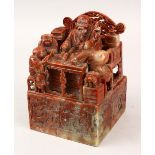 A GOOD 19TH CENTURY CHINESE CARVED SOAPSTONE SEAL OF A SEATED SCHOLAR AND ATTENDANTS, the scholar