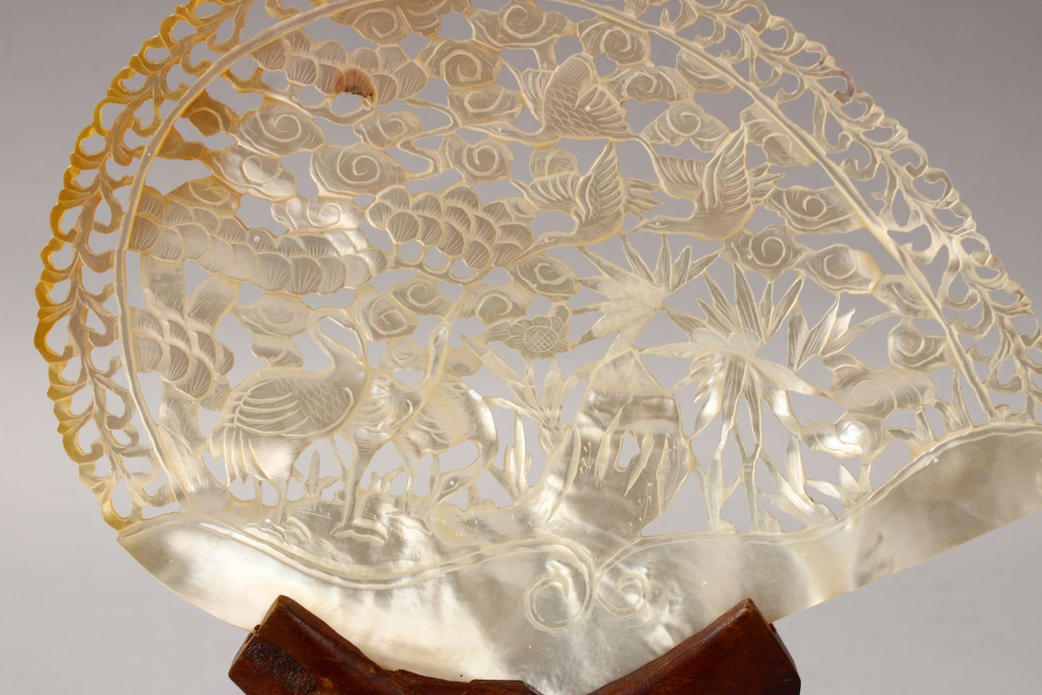 A CHINESE 20TH CENTURY CARVED MOTHER OF PEARL SHELL & STAND, the shell carved to depict scenes of - Image 2 of 2