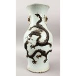A 19TH CENTURY CHINESE TWIN HANDLE MOULDED DRAGON VASE, a moulded dragon chasing a pearl upon a pale