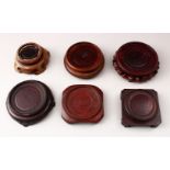 SIX 19TH / 20TH CENTURY CHINESE CARVED HARDWOOD STANDS, housing vases from 10.6cm diameter down to