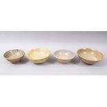 FOUR EARLY CHINESE POTTERY GLAZED BOWLS, some glazed, some partially glazed, various sized but