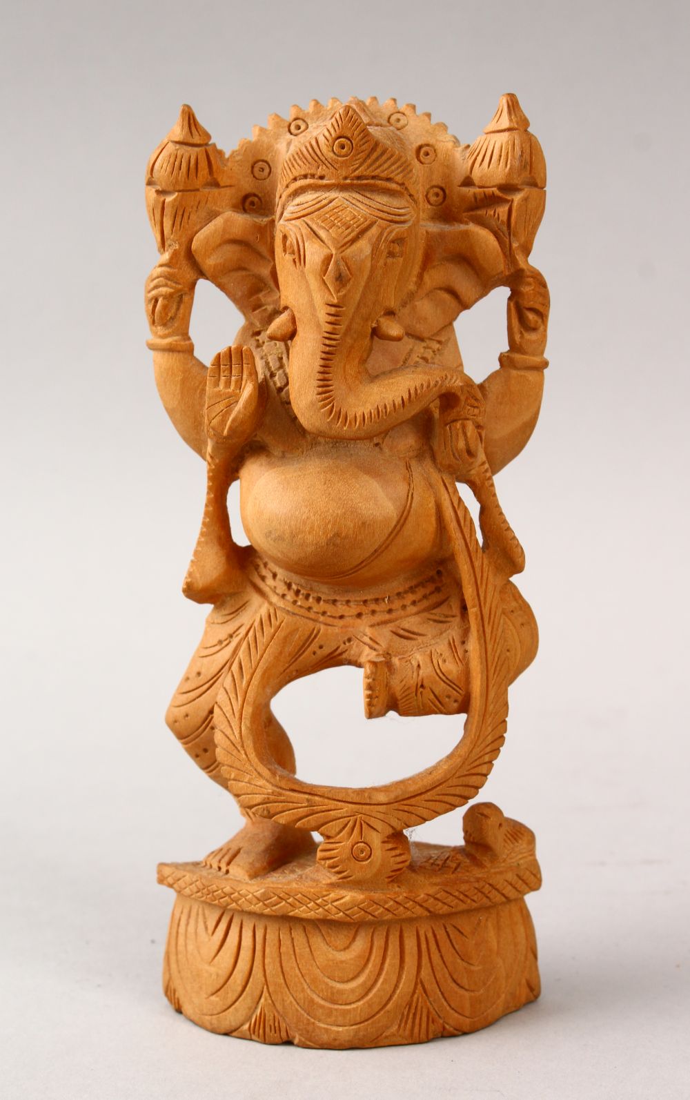 A 20TH CENTURY CARVED WOODEN INDIAN FIGURE OF GANESH, stood upon a carved base, 16cm high