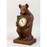 A BLACK FOREST STYLE CARVED BEAR MANTLE CLOCK. 12ins high.