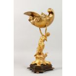 A GILT BRONZE CENTREPIECE, modelled as a young woman holding aloft a shell. 15.5ins high.