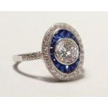 A SILVER ART DECO DESIGN FAUX SAPPHIRE RING.