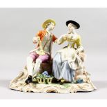 A GOOD 18TH CENTURY FURSTENBERG PORCELAIN GROUP OF YOUNG LOVERS, a basket of grapes at their feet.