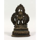 A SMALL BRONZE FIGURE OF A SEATED DEITY, with dark patination. 6.5ins high.