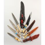 A COLLECTION OF NINE VARIOUS KNIVES, some with scabbards.
