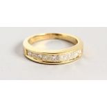 A YELLOW GOLD PRINCESS CUT DIAMOND HALF ETERNITY RING.