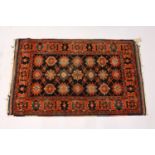 A SMALL PERSIAN RUG, 20TH CENTURY, dark blue ground with three rows of seven medallions, within a