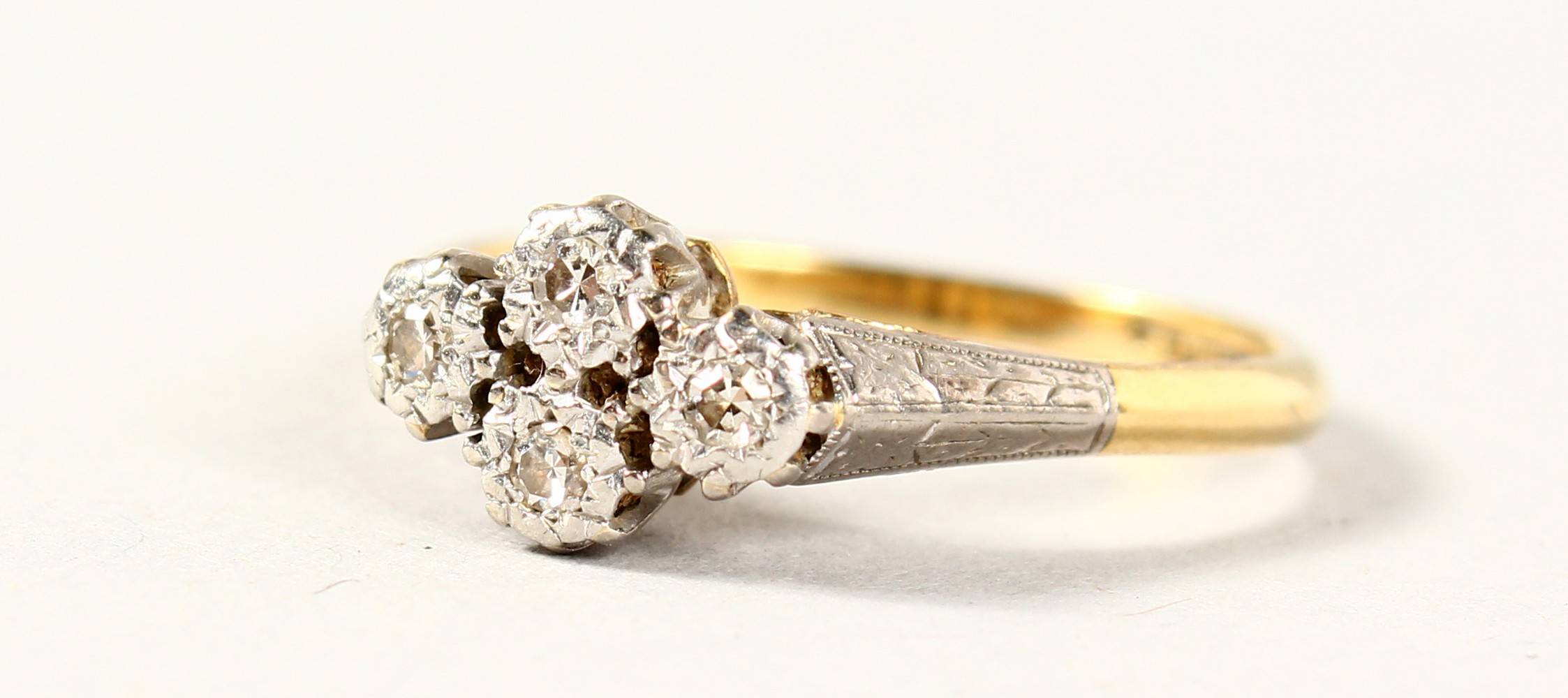 AN 18CT GOLD FOUR STONE CLOVER RING.