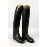 A PAIR OF BLACK LEATHER RIDING BOOTS, with wooden trees.