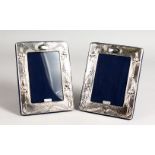 A PAIR OF ART NOUVEAU STYLE EMBOSSED SILVER PHOTOGRAPH FRAMES. 7.5ins x 5.75ins.