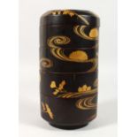 A JAPANESE CIRCULAR LACQUER FOUR SECTION BOX AND COVER, with gilded decoration. 10.5ins high.