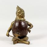 A BRONZE AND COCONUT INKWELL, modelled as a seated Chinese figure. 7ins high.