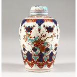 A CONTINENTAL POTTERY JAR AND COVER, printed in the Japanese Imari style. 8.5ins high.
