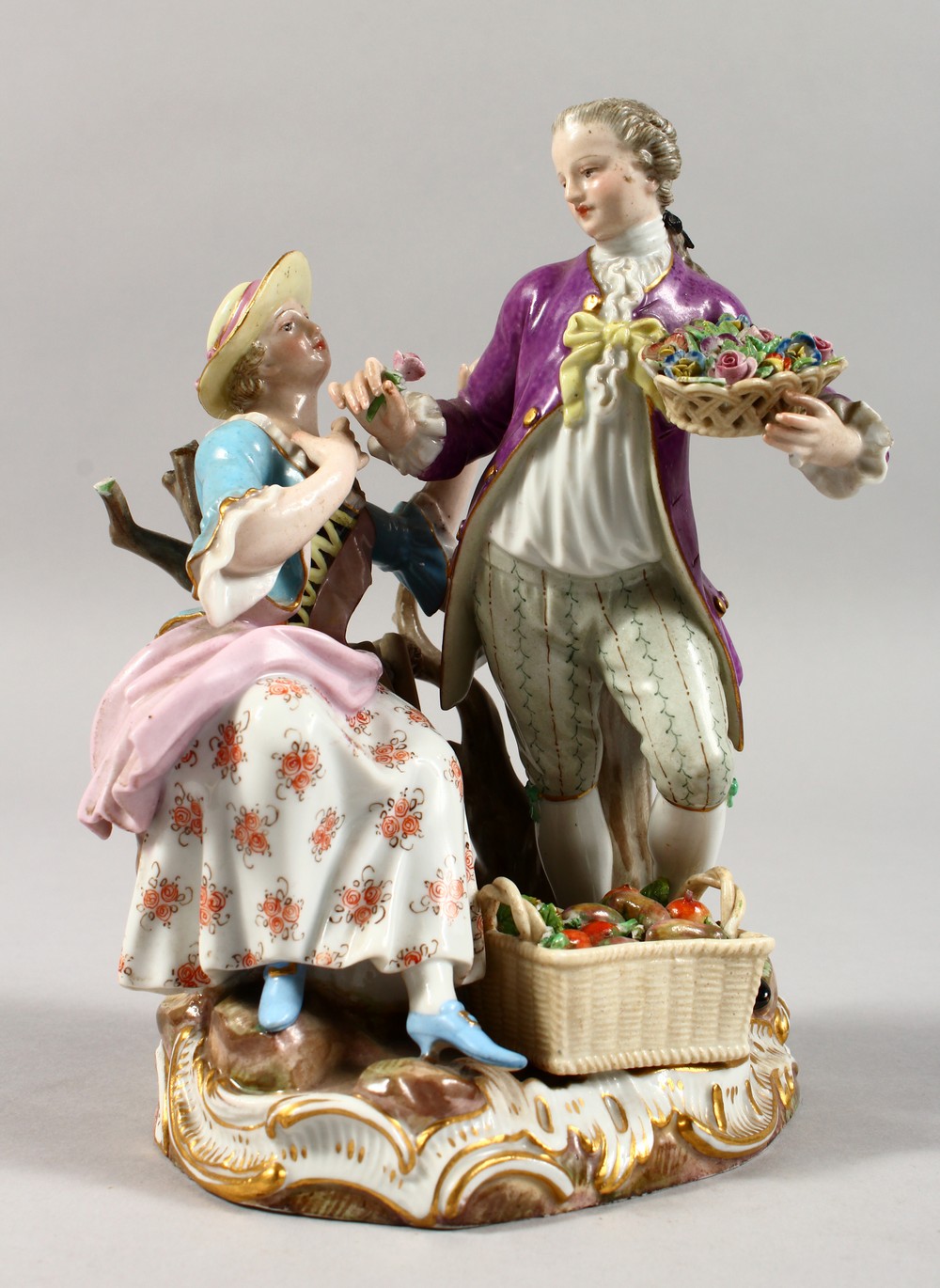 A 19TH CENTURY MEISSEN PORCELAIN GROUP OF A GALLANT AND LADY, with basket of fruit and flowers.