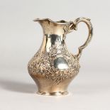 A VICTORIAN MILK JUG with floral repousse decoration. London.