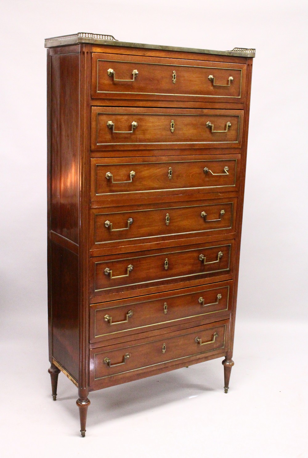 A 19TH CENTURY FRENCH MAHOGANY SEMAINIER, with brass galleried top, seven panelled drawers with